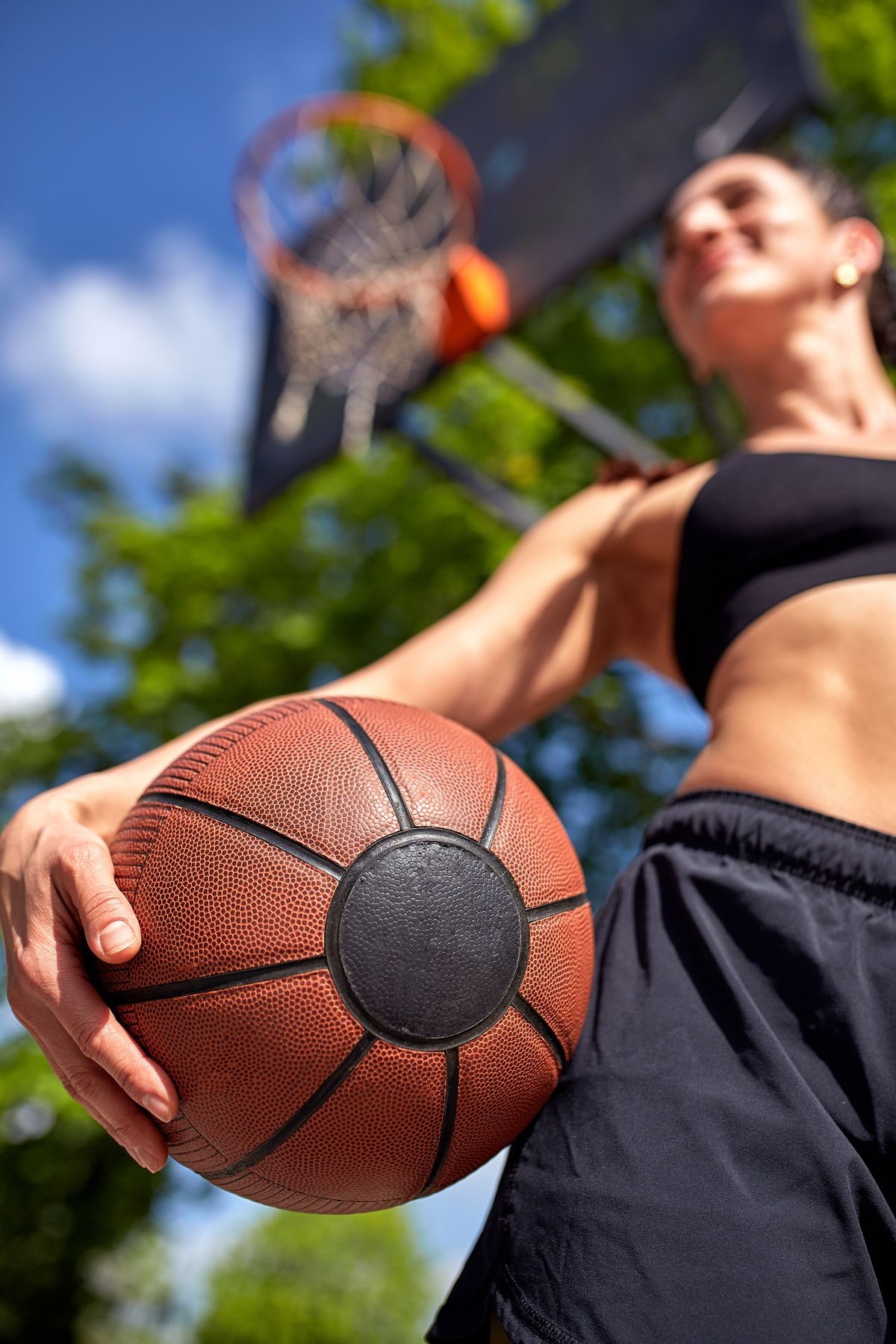 Beautiful sexy fitness girl in black sport wear with perfect body with basket ball at basketball court. Sport, fitness, lifestyle concept