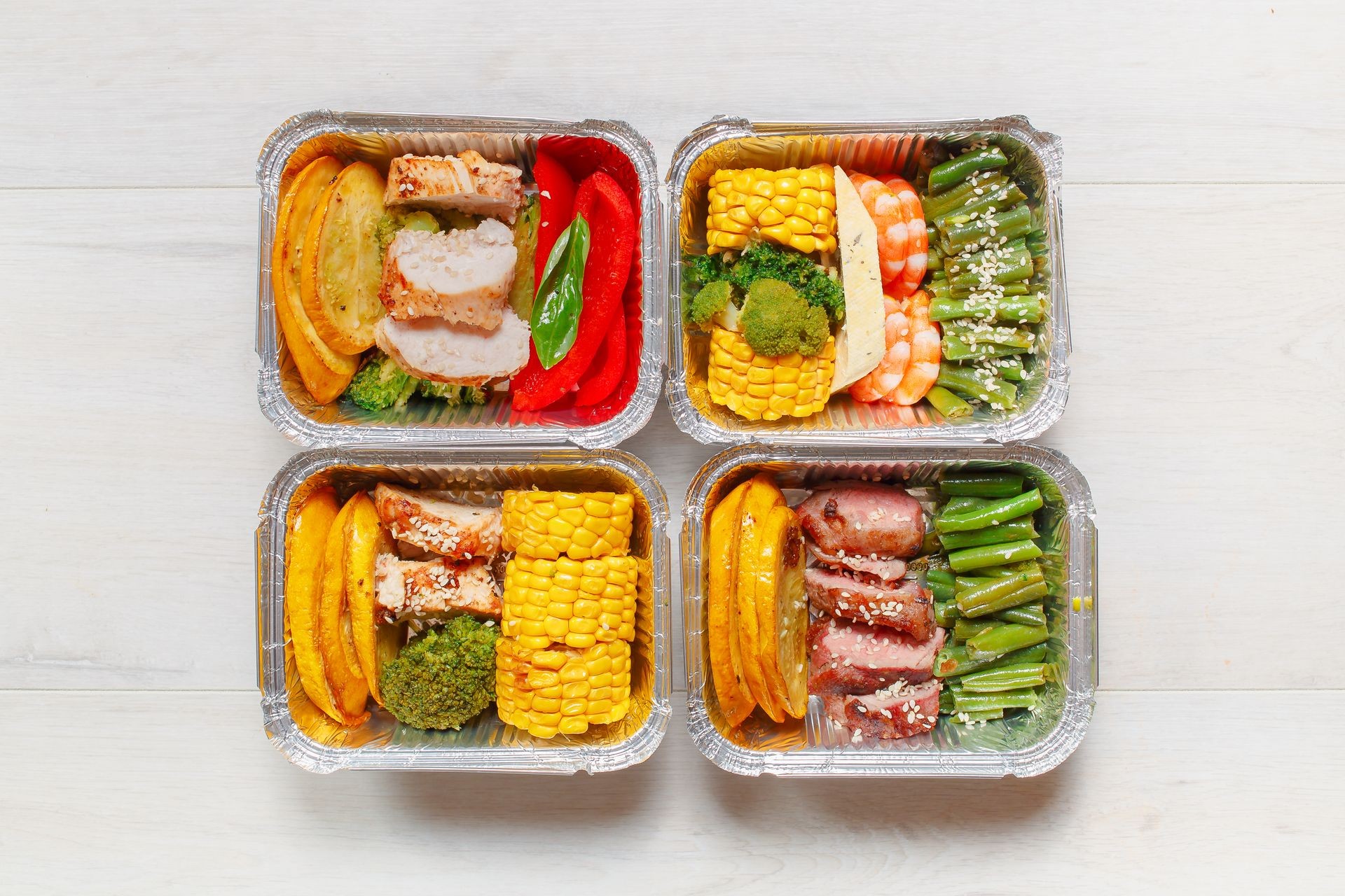 Healthy meal prep containers with vegetables, chicken, beef and shrimp grilled. Close-up, view top.